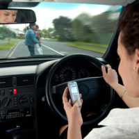 Lady looking at her phone while driving Lady looking at her phone while driving