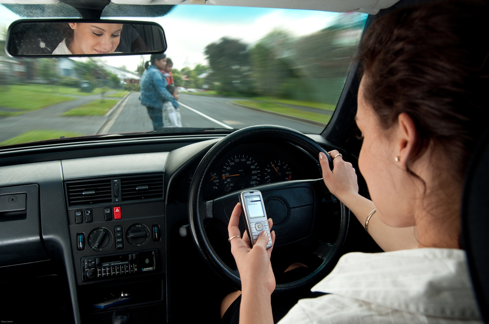 Lady looking at her phone while driving