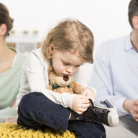 A baby sitting in the middle of a divorced couple A baby sitting in the middle of a divorced couple
