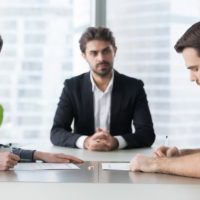 Spouses couple signing decree papers getting divorced in lawyers office Spouses couple signing decree papers getting divorced in lawyers office