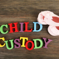 Baby's booties, dummy and colourful letters regarding child-custody and family-law concept