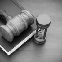 Judge gavel, hourglass and legal book on wooden table, court time concept Judge gavel, hourglass and legal book on wooden table, court time concept