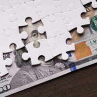 American dollar hidden under puzzle pieces