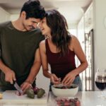 Loving couple cutting vegetables together in kitchen