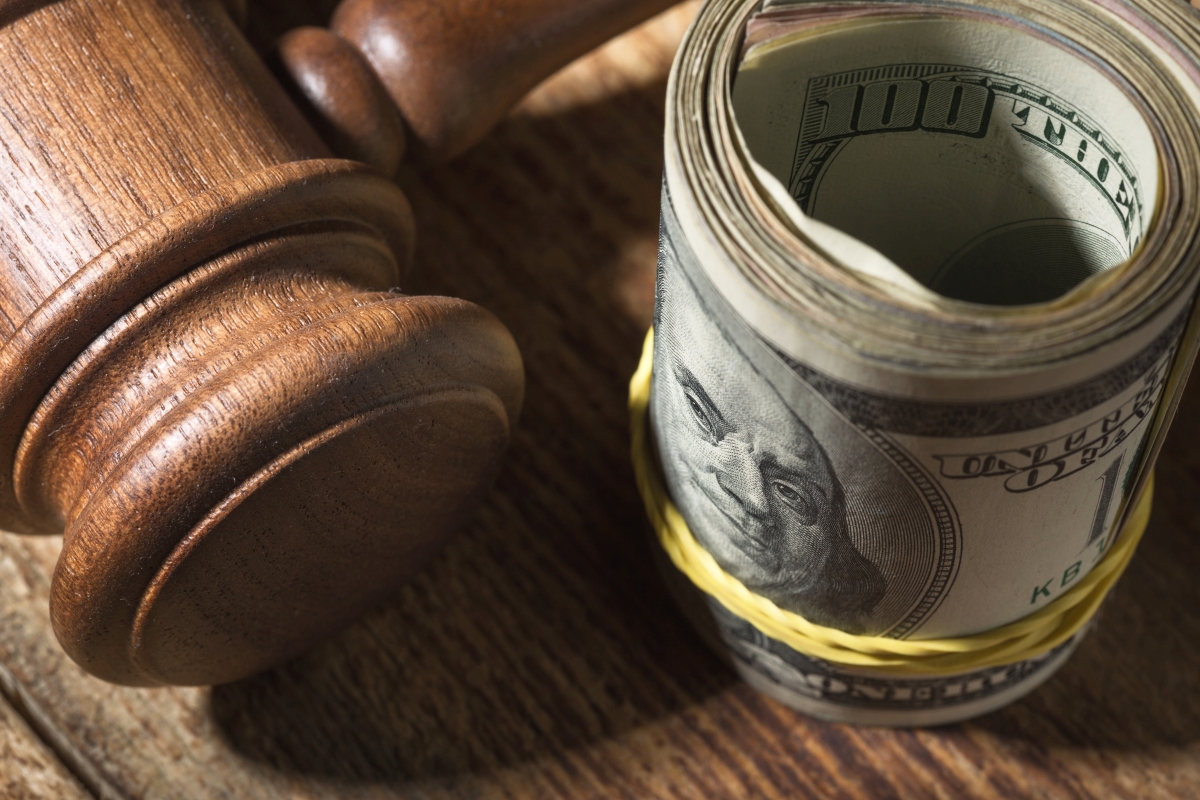 Money roll and judges hammer on wooden table