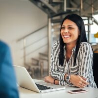 Young smiling saleswoman talking with a client.