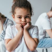 selective focus of sad african american kid touching face near d