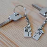 Pendant of key ring in shape of house divided in two parts on wo Pendant of key ring in shape of house divided in two parts on wo