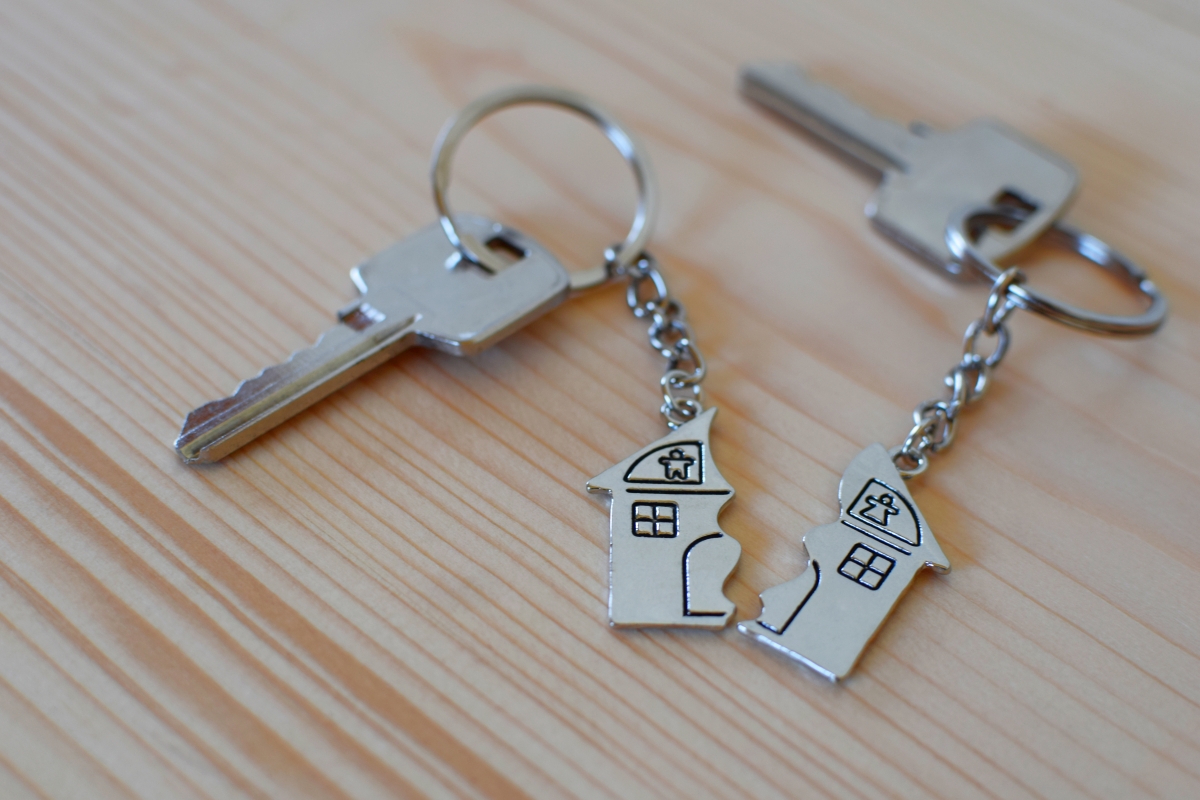 Pendant of key ring in shape of house divided in two parts on wo