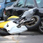 Car and motorcycle accident outdoors.