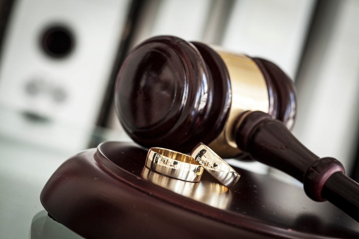 Divorce concept with gavel and wedding rings