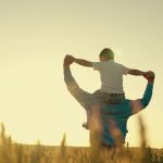 Agriculture. happy father farmer carries son child boy sunset. child sits happily his father shoulders wheat field. dad love child kid. beloved kid son arms his father. papa day. summer family walk sunset.