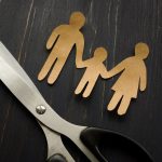 Parental alienation concept. Figures of family and scissors as symbol of divorce.