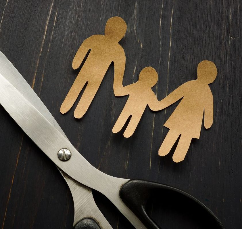 Parental alienation concept. Figures of family and scissors as symbol of divorce.