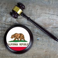 Wooden judgement or auction mallet with of California flag. Conceptual image.