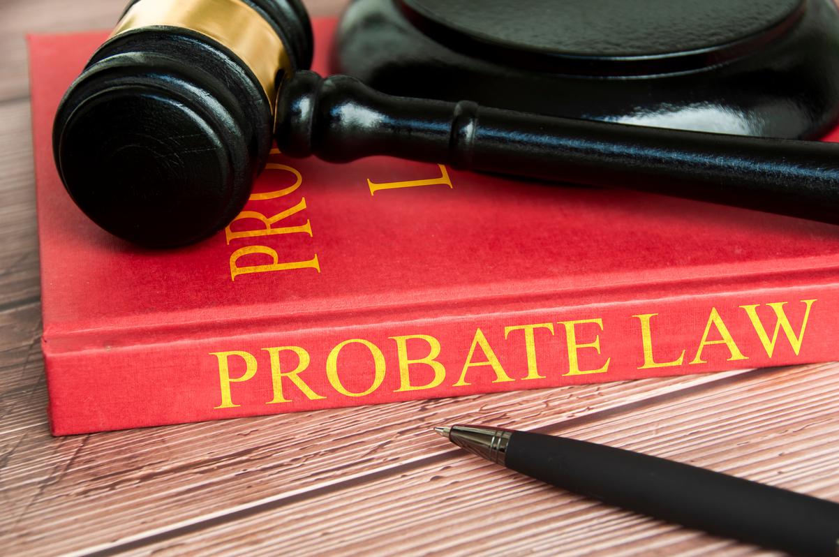 Close-up view of a red book titled "PROBATE LAW in gold lettering. A black judge