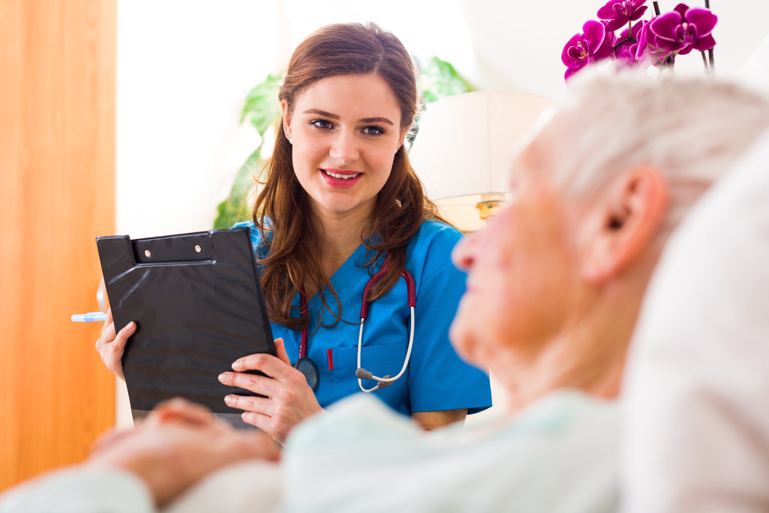 Kind nurse with clipboard in her hands registering senior woman